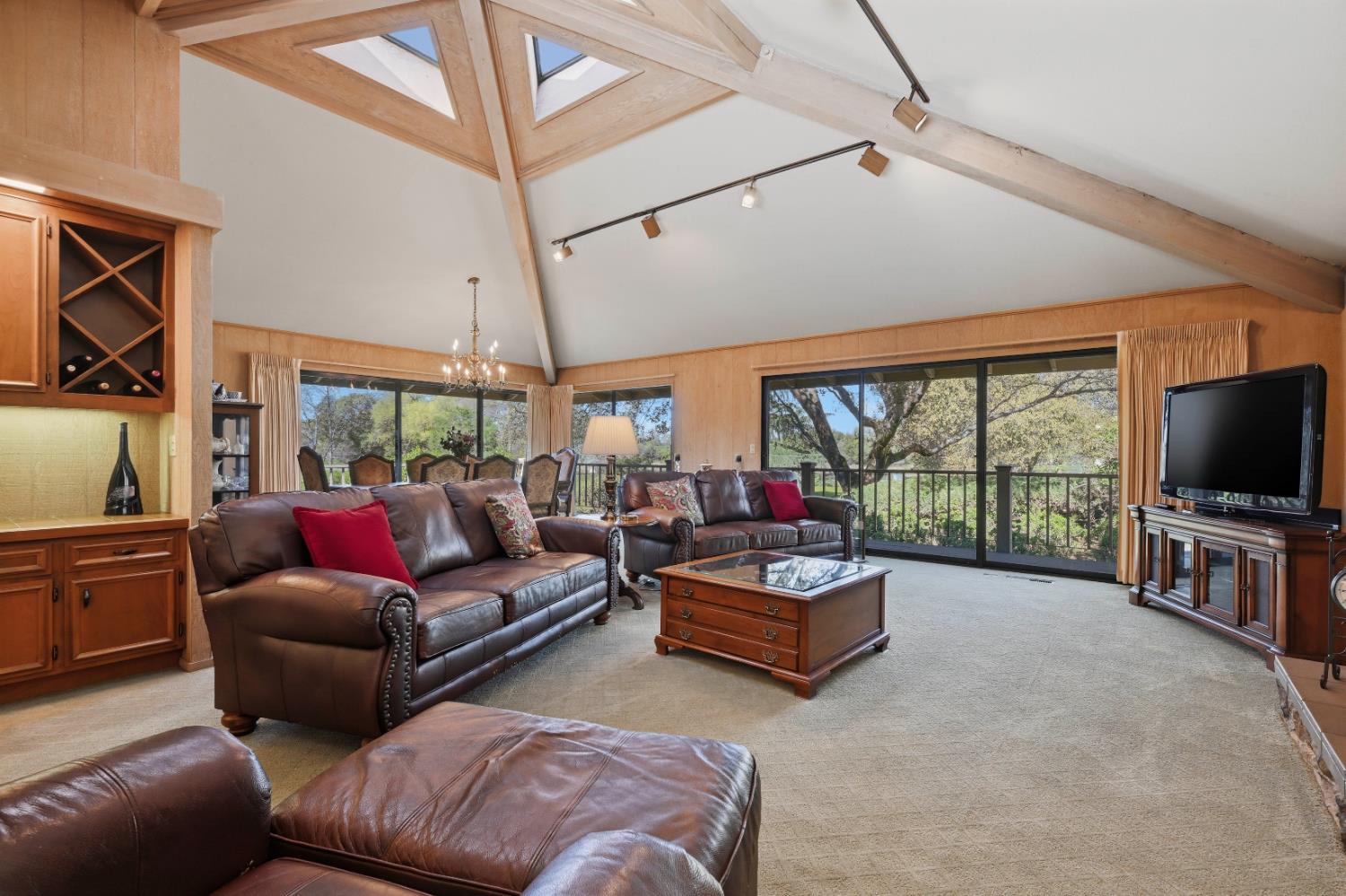 8860 Auburn Valley Road Auburn, CA 95602 - Photo 13 of 46 a living room with furniture a flat screen tv and a floor to ceiling window