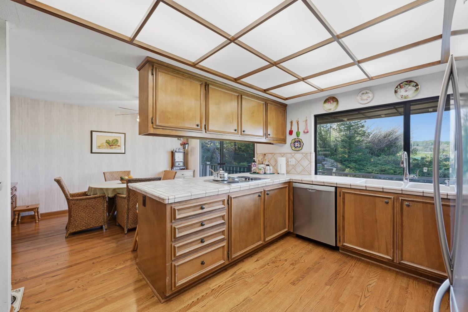8860 Auburn Valley Road Auburn, CA 95602 - Photo 20 of 46 a kitchen with a stove a sink and wooden cabinets