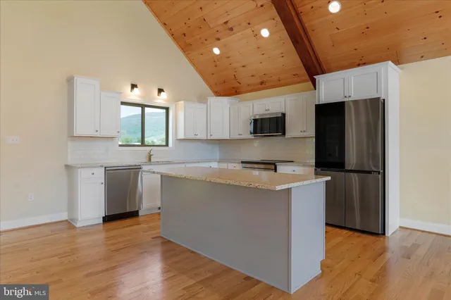 a kitchen with a sink a microwave a refrigerator and cabinets