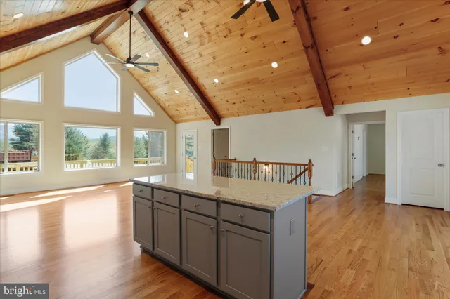 a kitchen with a sink a wooden floor and a large window