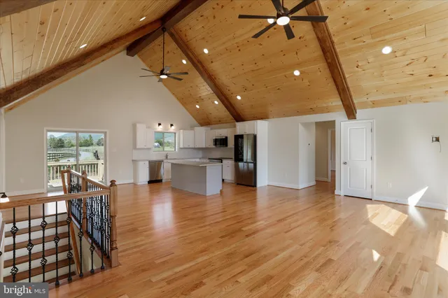 a living room with stainless steel appliances with wooden floor