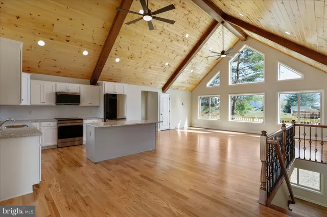 a large kitchen with stainless steel appliances granite countertop a stove and a large window