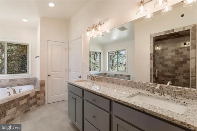 a bathroom with a granite countertop sink and a large mirror