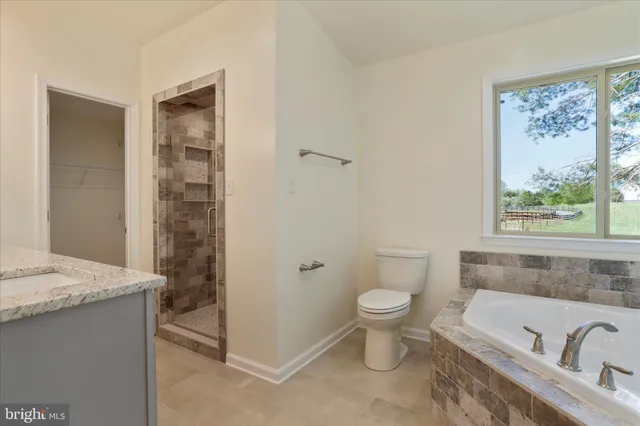 a bathroom with a granite countertop sink a toilet and shower