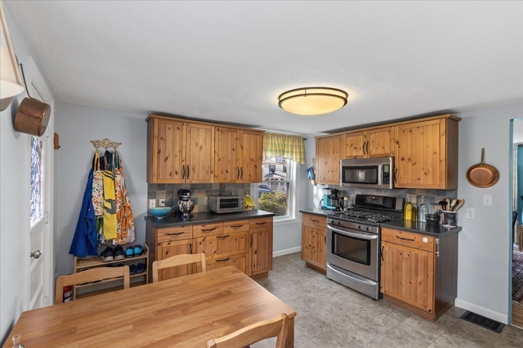 9 John Street Waltham, MA 02453 - Photo 20 of 43 a kitchen with stainless steel appliances granite countertop a stove a sink and a microwave