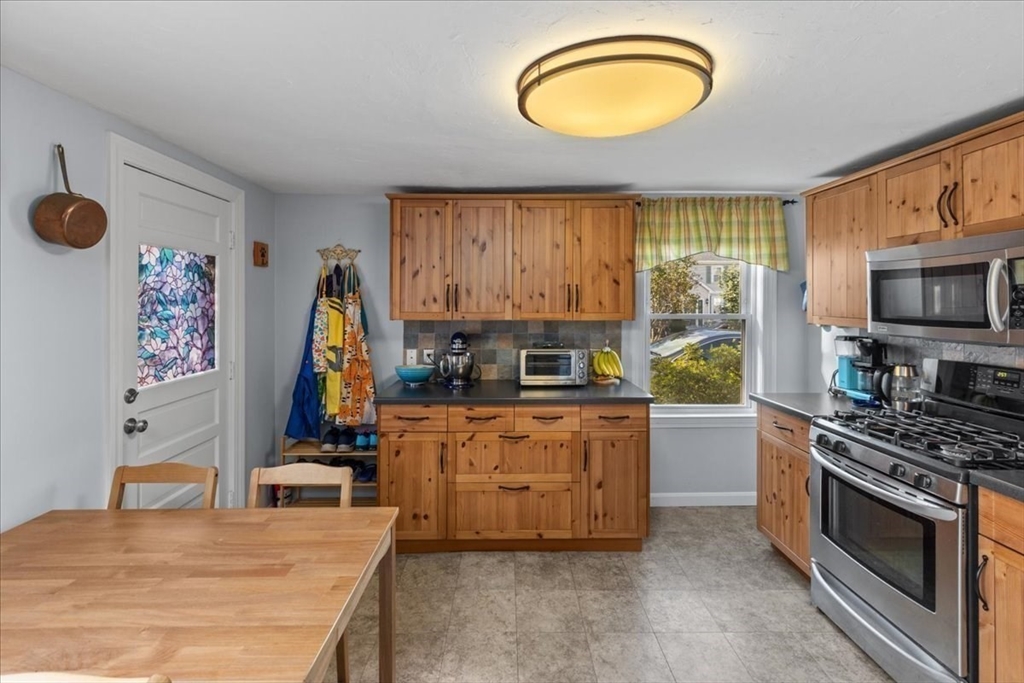 9 John Street Waltham, MA 02453 - Photo 21 of 43 a kitchen with stainless steel appliances granite countertop a stove a sink and a microwave