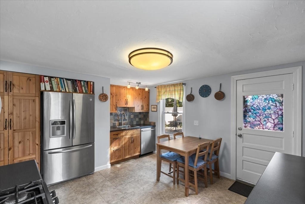 9 John Street Waltham, MA 02453 - Photo 22 of 43 a kitchen with stainless steel appliances granite countertop a refrigerator a stove a dining table and chairs
