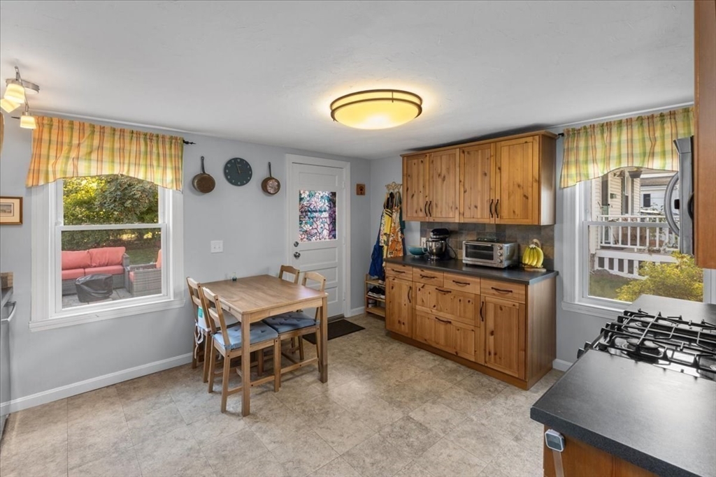 9 John Street Waltham, MA 02453 - Photo 23 of 43 a kitchen with a table chairs and a stove