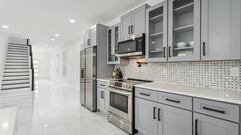 3311 Rutz Street Dallas, TX 75212 - Photo 5 of 21 a kitchen with stainless steel appliances white cabinets and a stove top oven