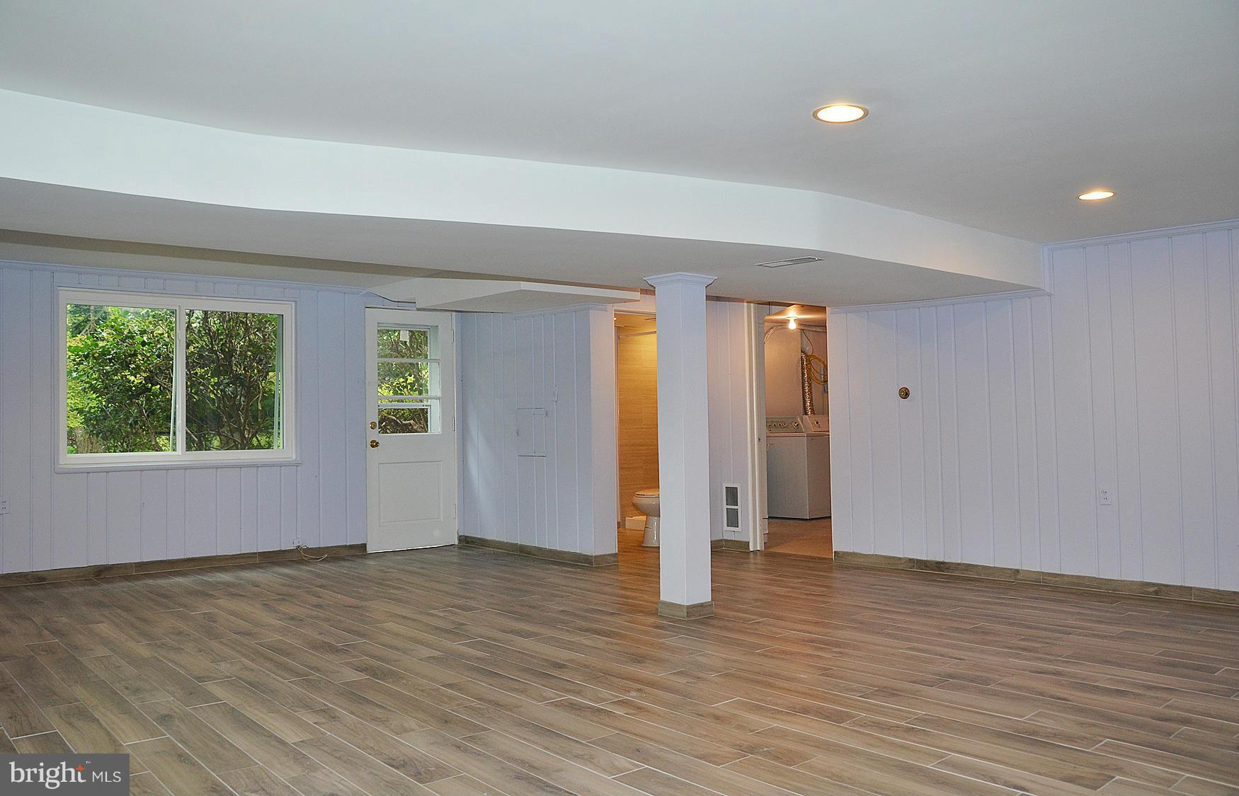 9710 Holmhurst Road Bethesda, MD 20817 - Photo 12 of 18 an empty room with wooden floor and windows