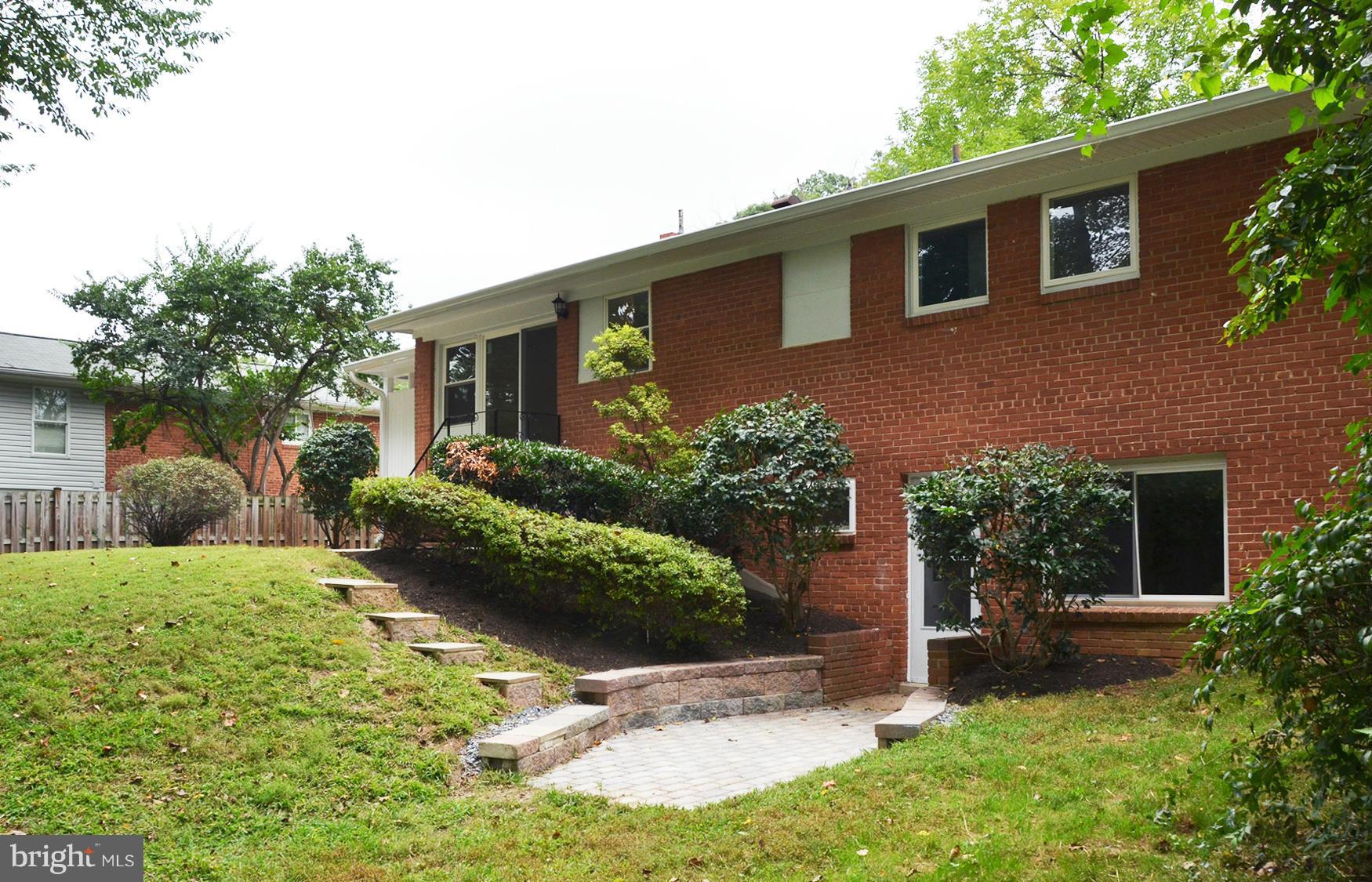 9710 Holmhurst Road Bethesda, MD 20817 - Photo 18 of 18 a front view of a house with a yard and potted plants