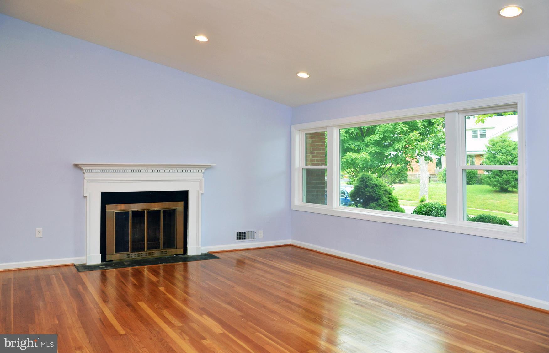 9710 Holmhurst Road Bethesda, MD 20817 - Photo 4 of 18 a view of an empty room with a window and a fireplace