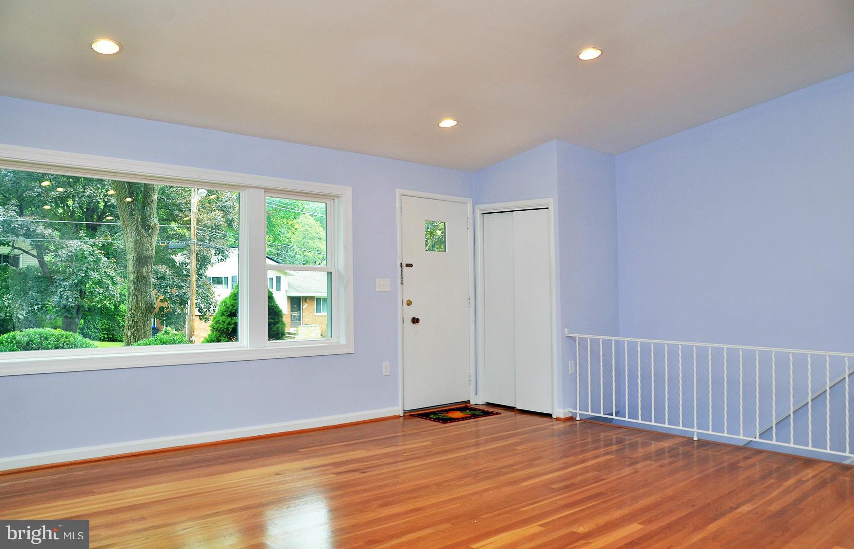 9710 Holmhurst Road Bethesda, MD 20817 - Photo 6 of 18 a view of an empty room with wooden floor and a window