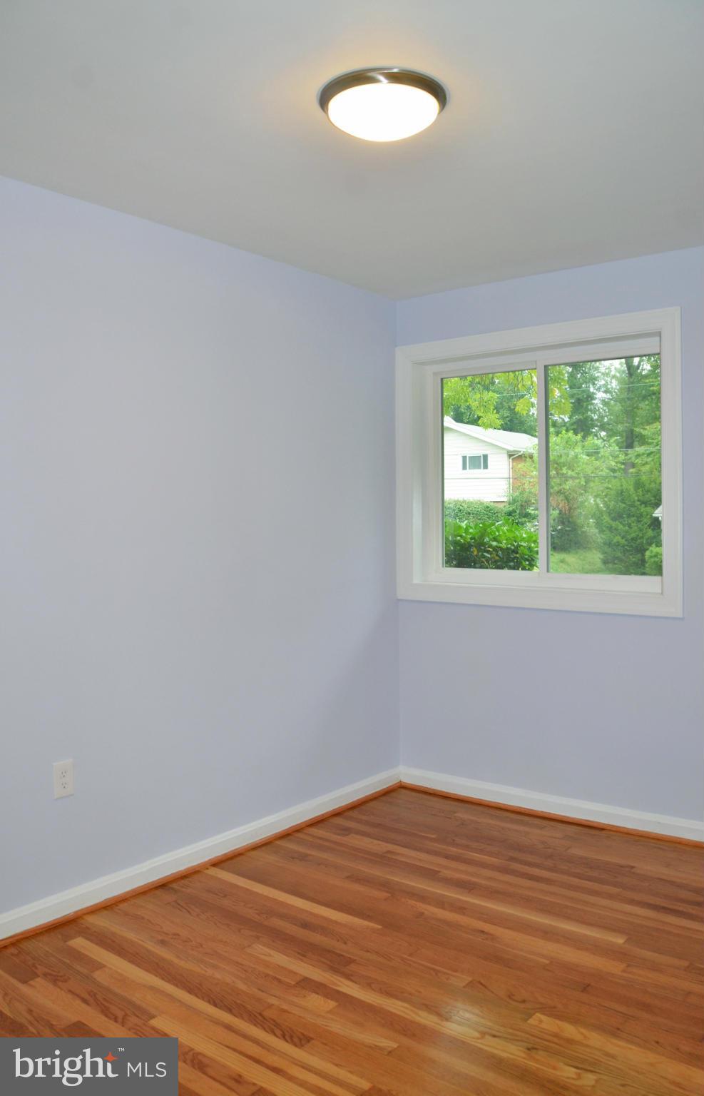 9710 Holmhurst Road Bethesda, MD 20817 - Photo 8 of 18 a view of empty room with wooden floor and fan