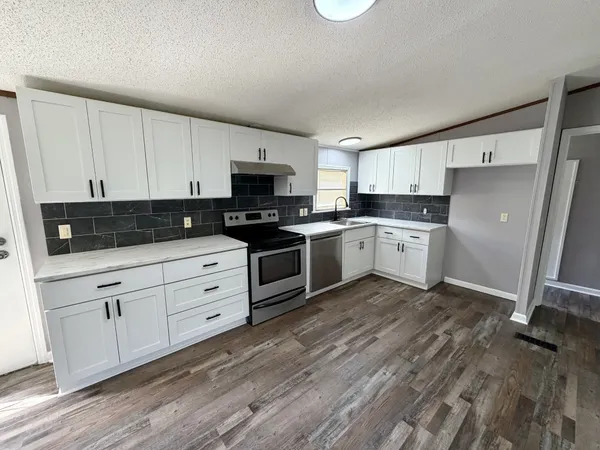 a kitchen with white cabinets stainless steel appliances and sink