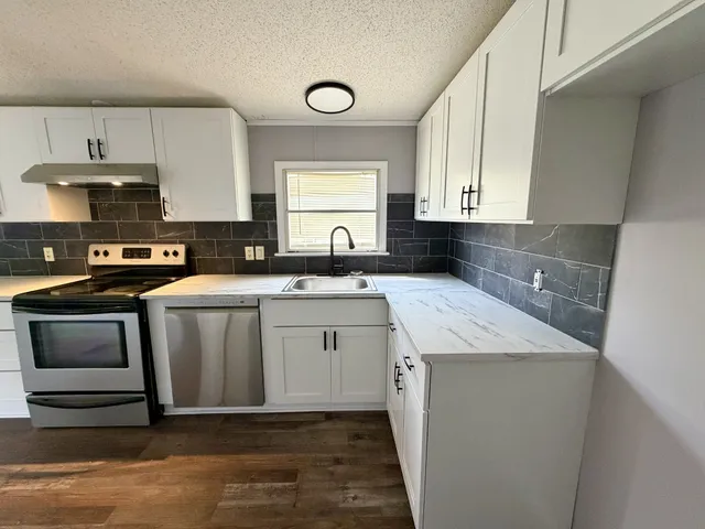 a kitchen with a sink stove and cabinets