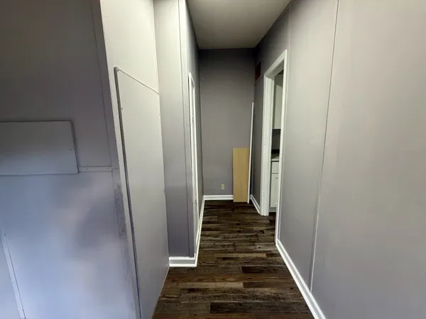 a view of a hallway with wooden floor and staircase