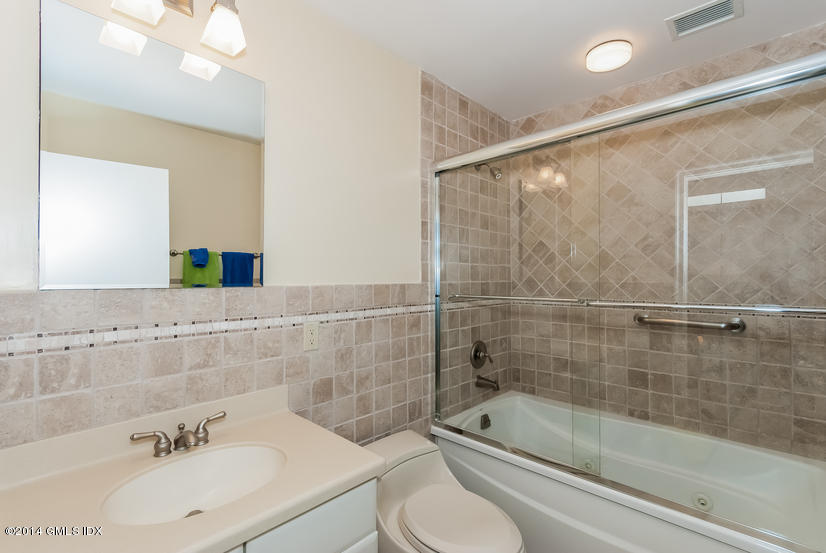 18 Hidden Brook Road Riverside, CT 06878 - Photo 18 of 32 a bathroom with a bathtub shower sink vanity and toilet