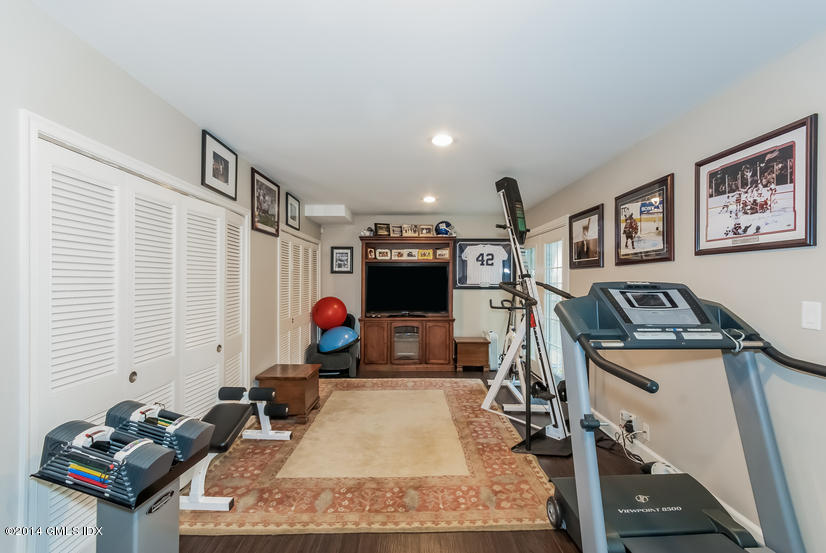 18 Hidden Brook Road Riverside, CT 06878 - Photo 24 of 32 a room with gym equipment and a flat screen tv