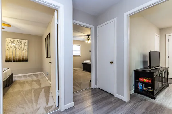 a view of a hallway with wooden floor and a living room