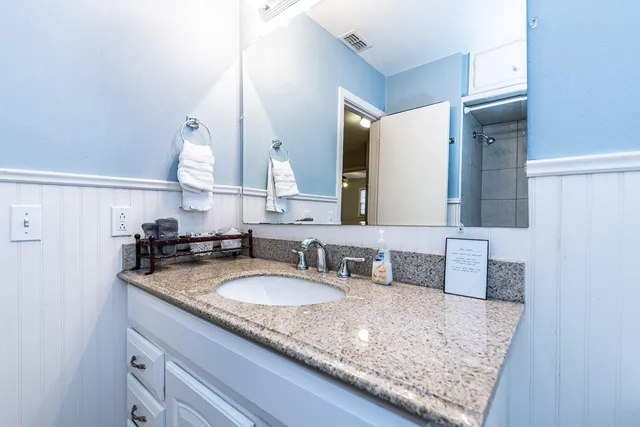 a bathroom with a granite countertop sink and a mirror