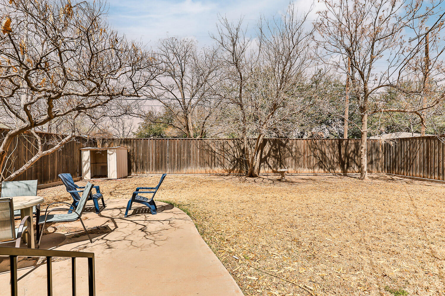 3504 38th Street Lubbock, TX 79413 - Photo 4 of 28 a view of a backyard with table and chairs under a large tree
