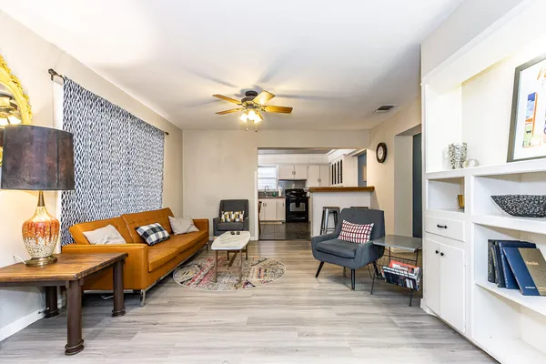a living room with furniture and a flat screen tv with kitchen view