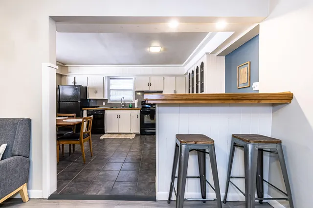 a kitchen with stainless steel appliances granite countertop a refrigerator a stove and a sink with wooden floor