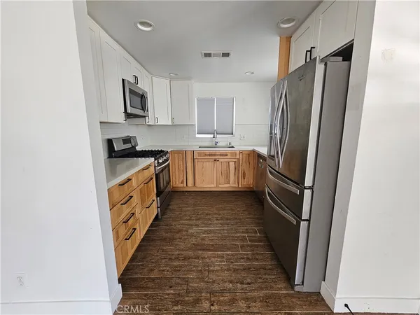 a kitchen with stainless steel appliances a refrigerator and a stove top oven