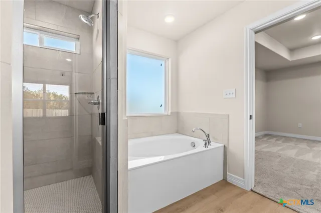 a white bath tub sitting next to a shower