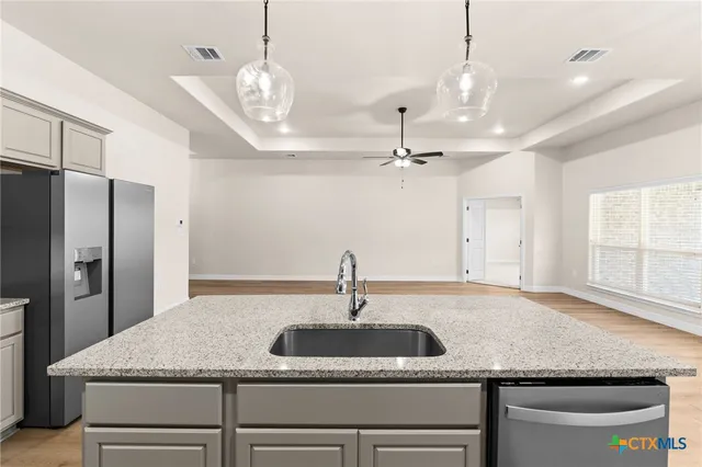 a kitchen with a sink a center island and stainless steel appliances