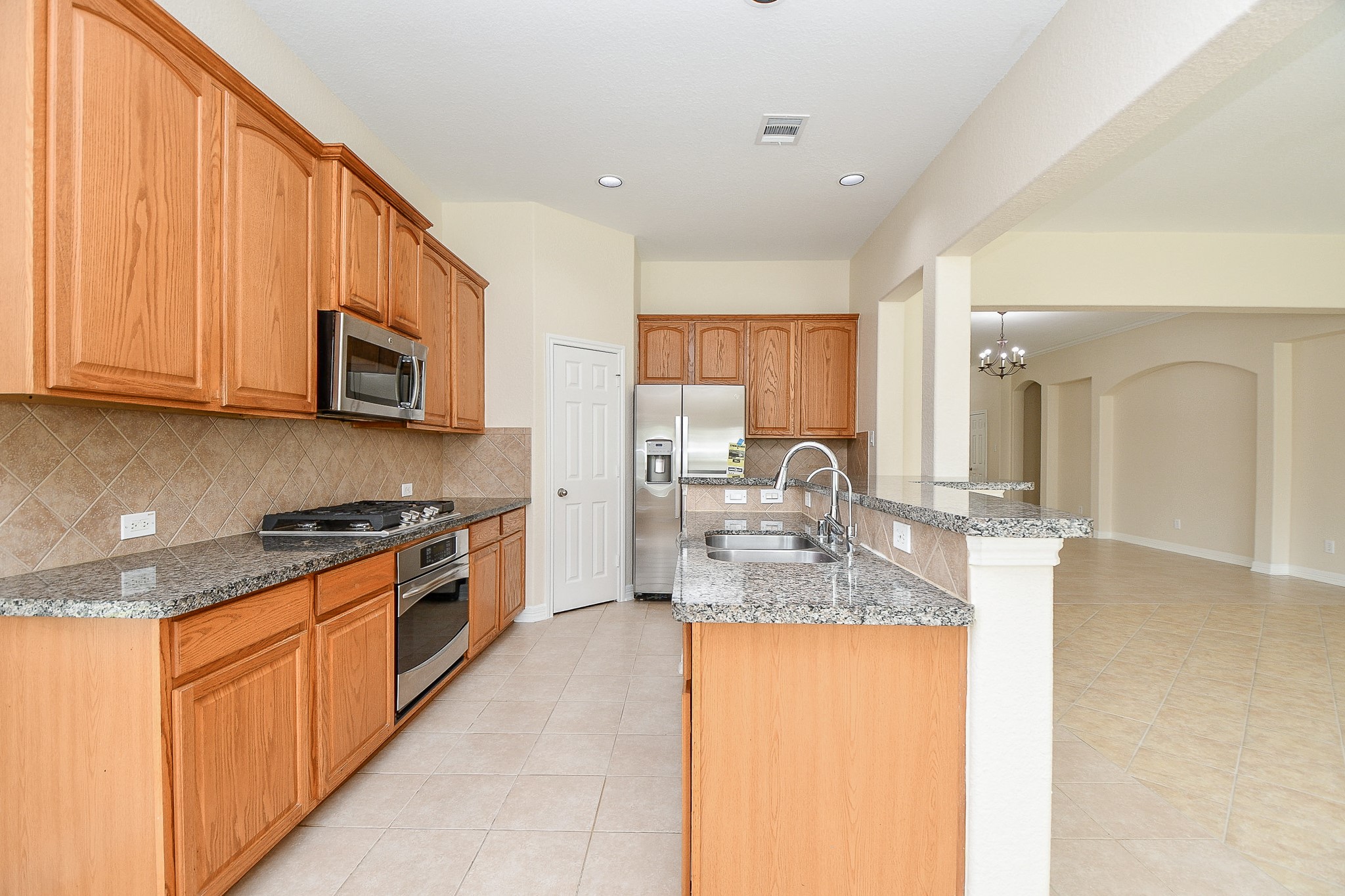 12104 Dawn Mist Court Pearland, TX 77584 - Photo 21 of 31 a kitchen with stainless steel appliances granite countertop a stove top oven a sink a dining table and chairs