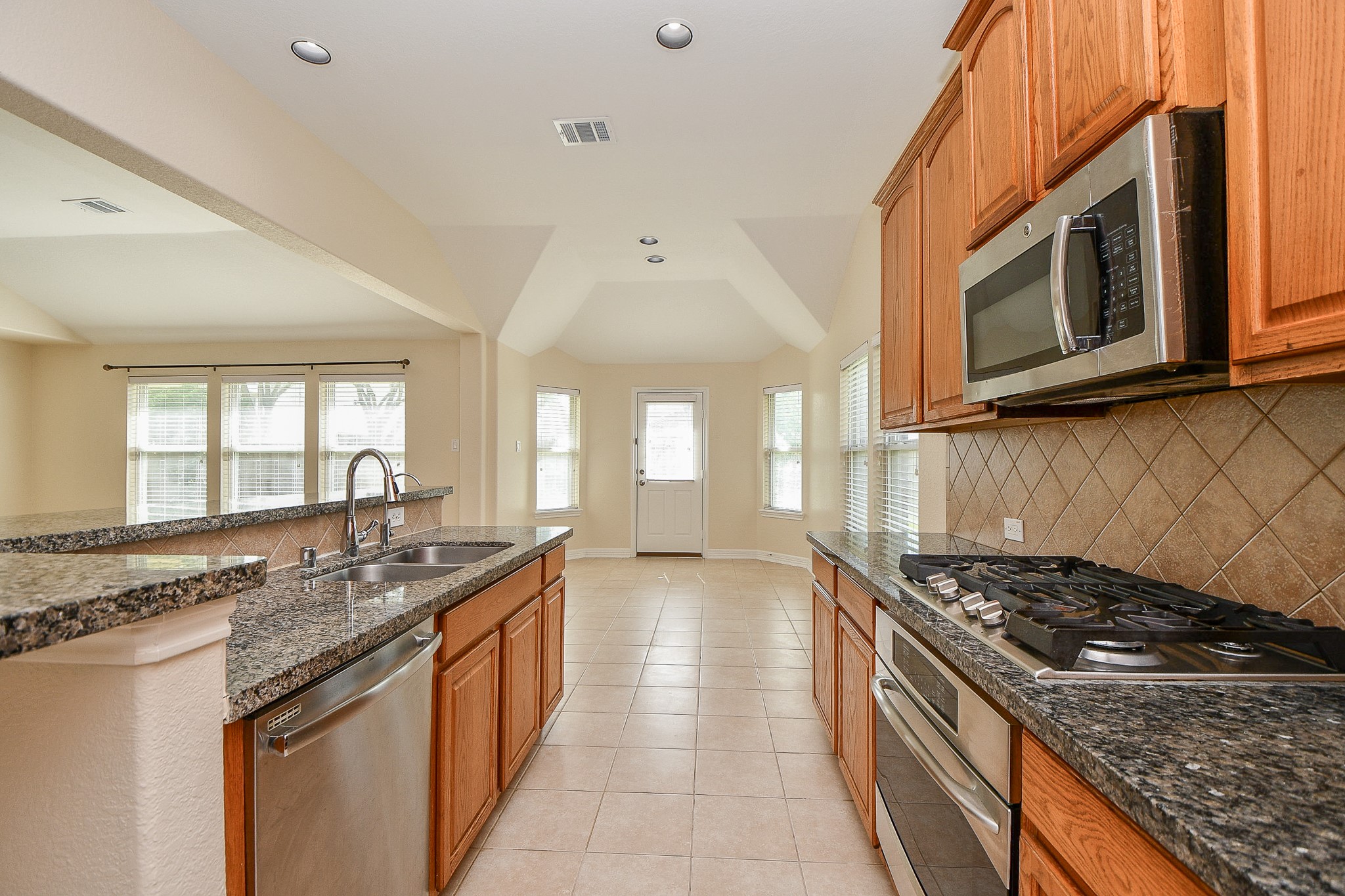 12104 Dawn Mist Court Pearland, TX 77584 - Photo 24 of 31 a kitchen with stainless steel appliances granite countertop a stove and a microwave