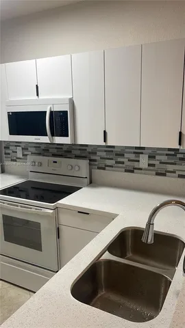 a kitchen with stainless steel appliances a stove sink and microwave