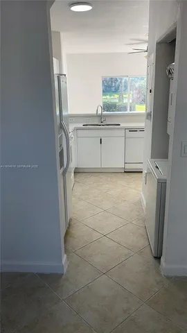 a view of kitchen with refrigerator and window