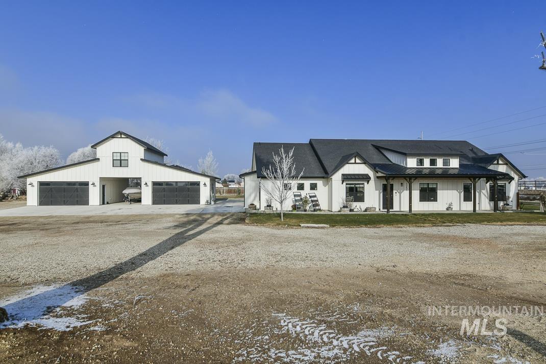 1251 South Swan Falls Road Kuna, ID 83634 - Photo 1 of 1 Modern farmhouse style home with an outdoor structure, board and batten siding, a standing seam roof, a garage, and driveway