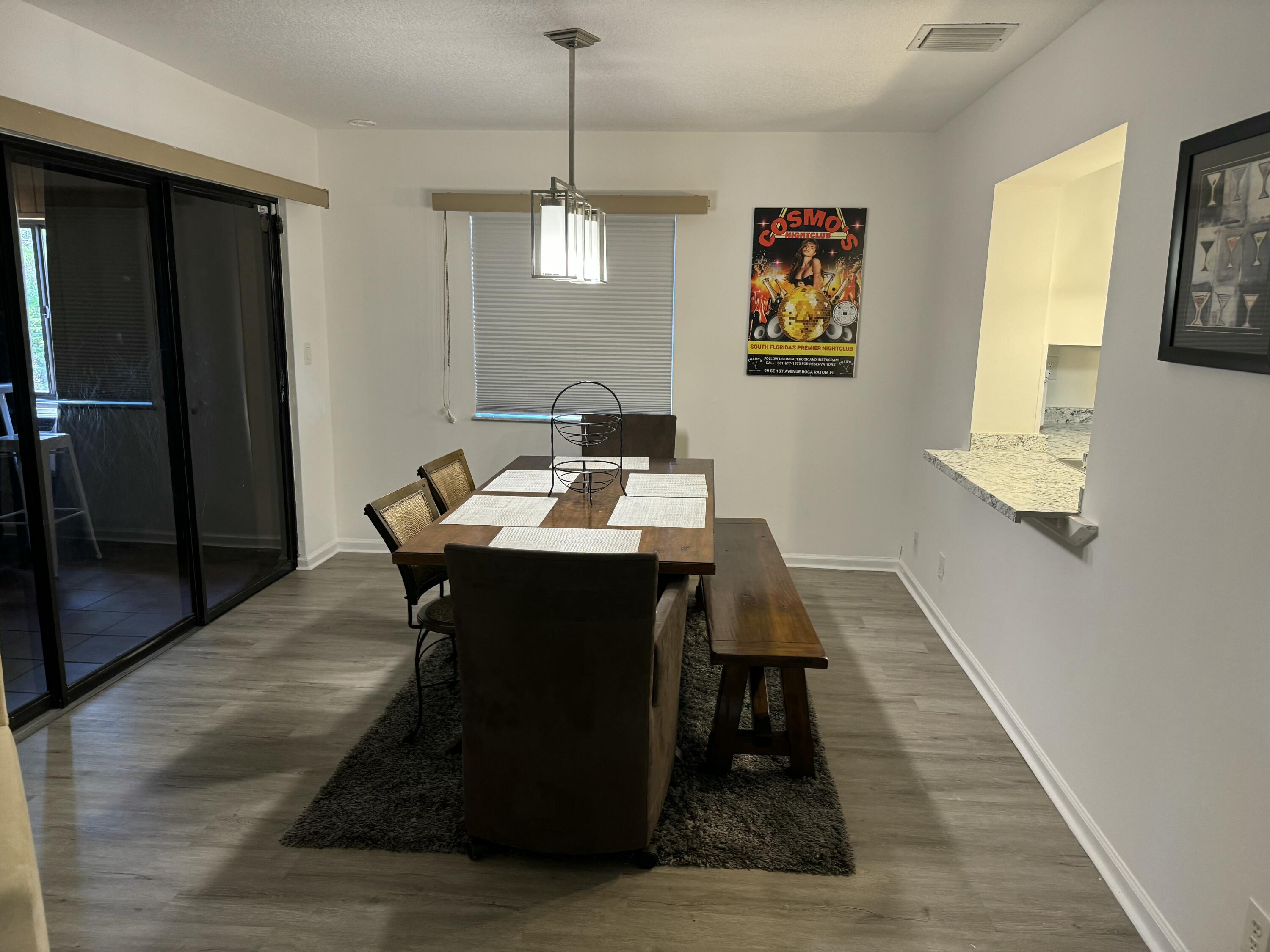 4600 Northeast 4th Avenue Boca Raton, FL 33431 - Photo 10 of 36 a dining room with wooden floor a chandelier a wooden table and chairs