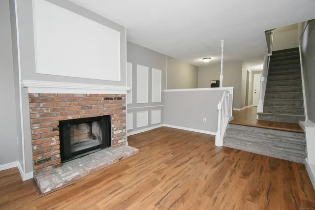 a view of a livingroom with wooden floor and a fireplace
