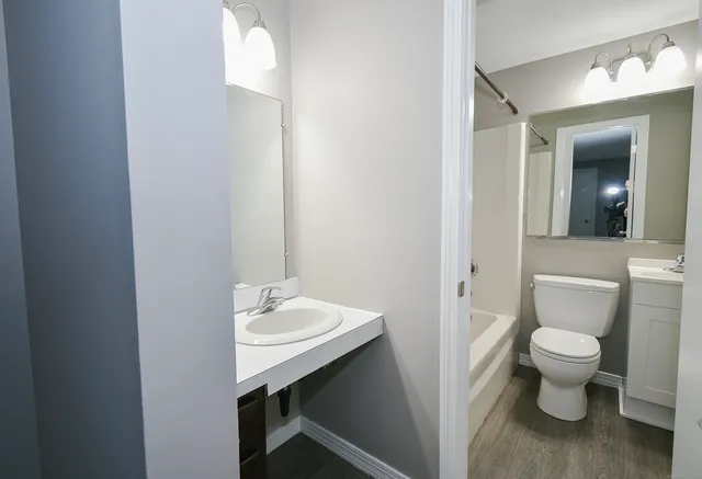 a bathroom with a toilet sink and mirror