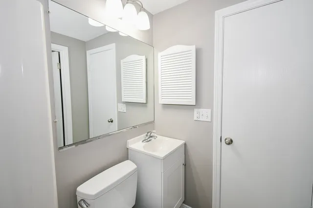 a bathroom with a toilet a sink and a mirror
