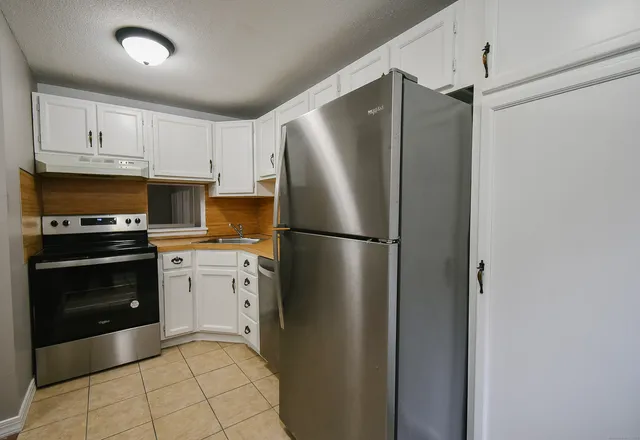 a kitchen with stainless steel appliances a refrigerator sink and cabinets