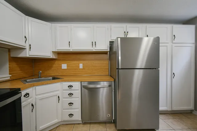 a kitchen with stainless steel appliances a refrigerator sink and cabinets
