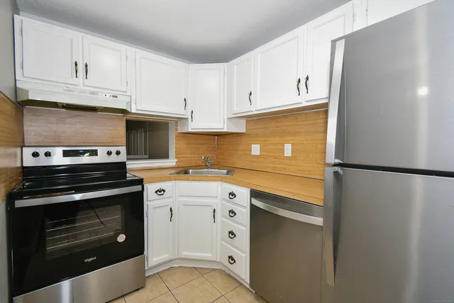 a kitchen with white cabinets and stainless steel appliances