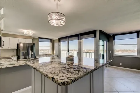 a kitchen with stainless steel appliances granite countertop sink stove and refrigerator