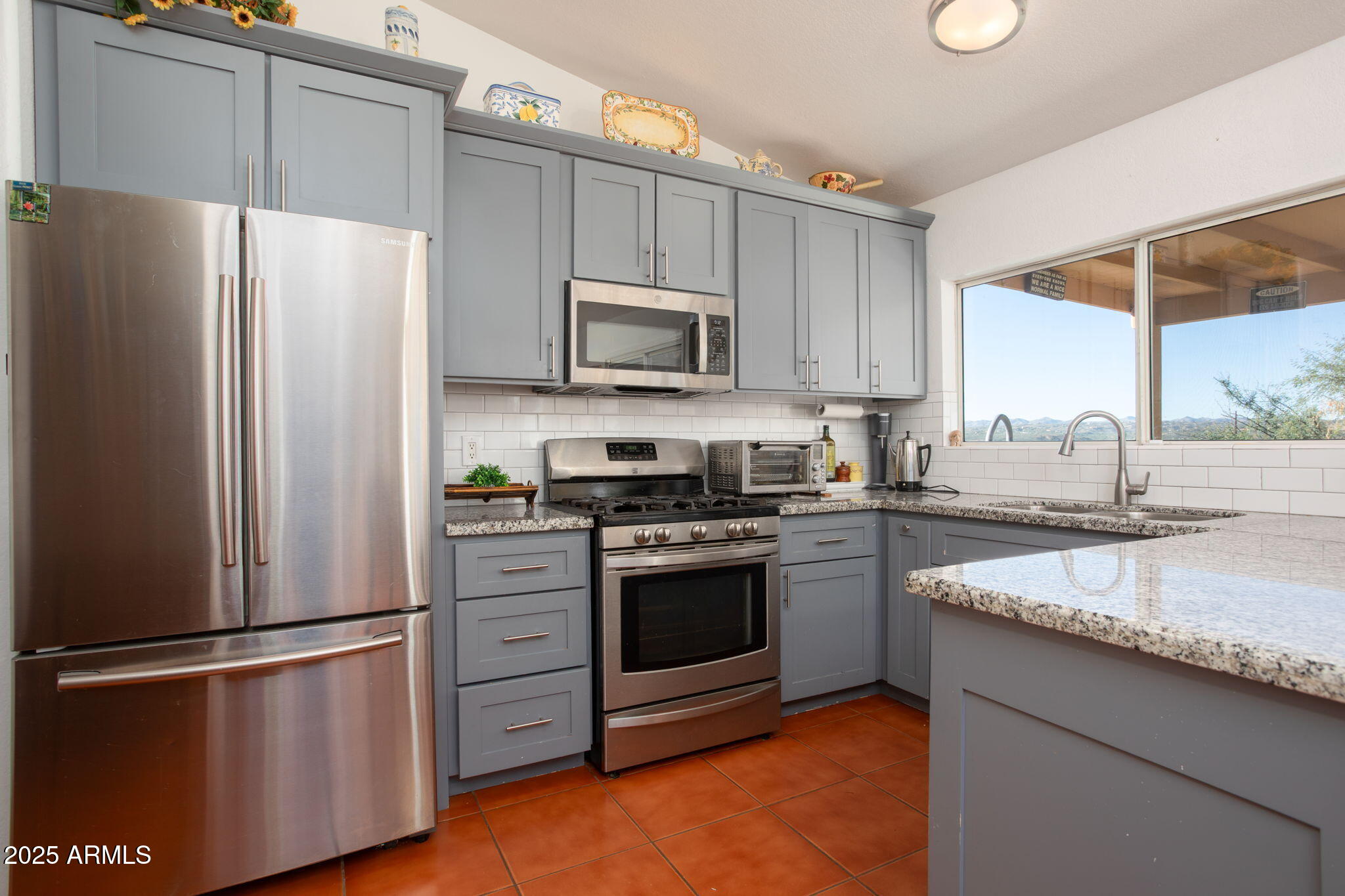 418 Cancun Court Rio Rico, AZ 85648 - Photo 13 of 36 a kitchen with granite countertop stainless steel appliances a refrigerator a sink and a stove