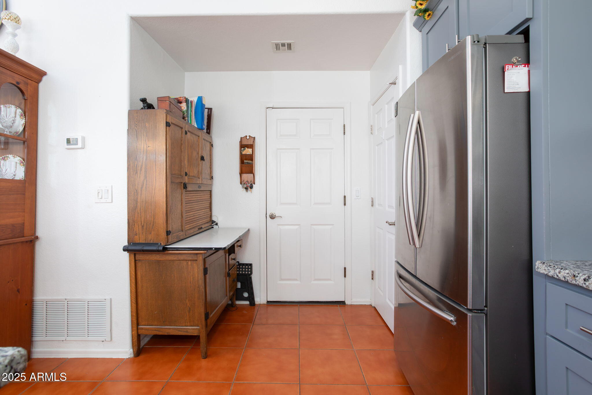 418 Cancun Court Rio Rico, AZ 85648 - Photo 14 of 36 a view of a refrigerator in kitchen and an empty room with wooden floor