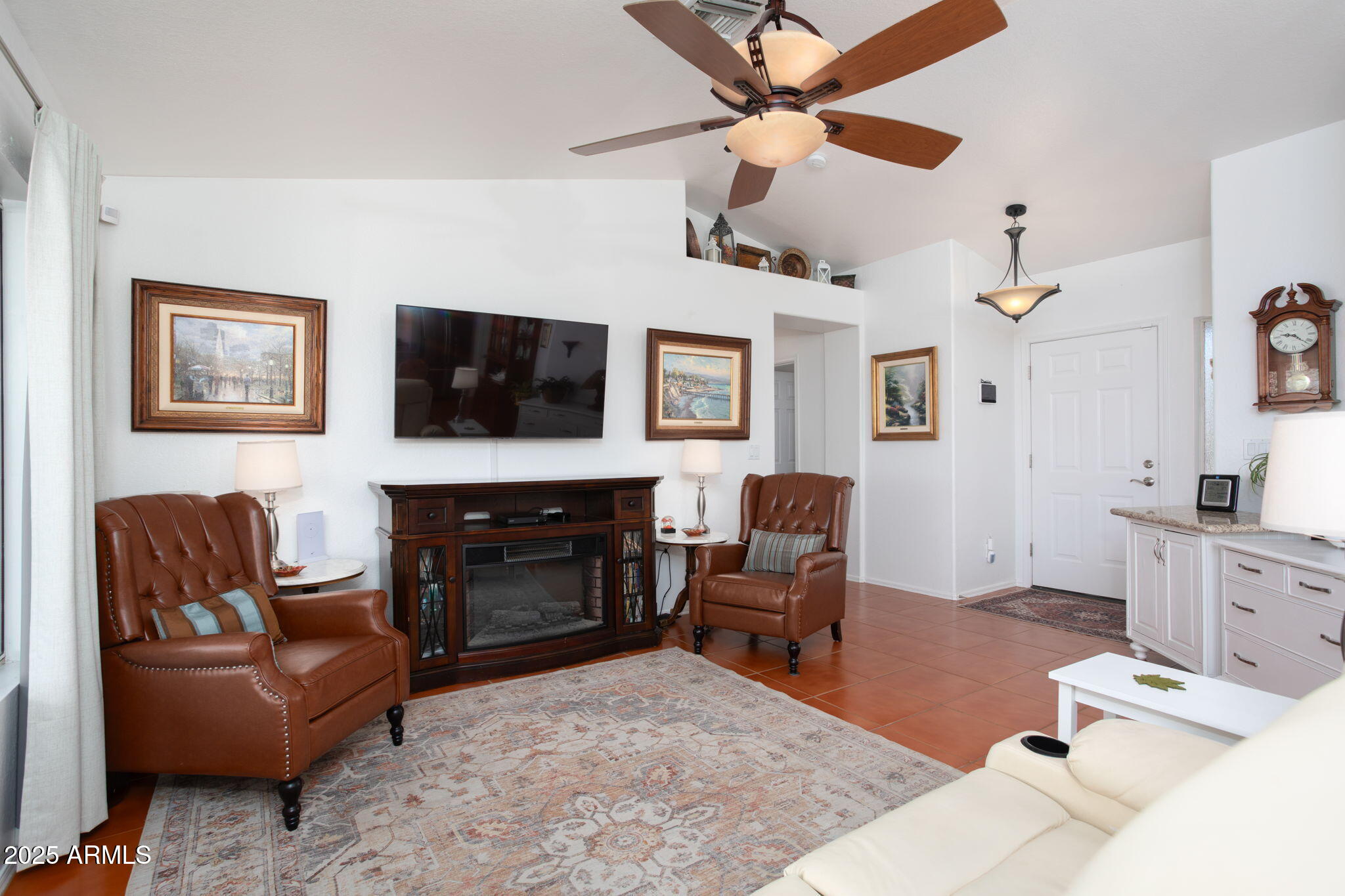 418 Cancun Court Rio Rico, AZ 85648 - Photo 8 of 36 a living room with furniture a flat screen tv and a fireplace