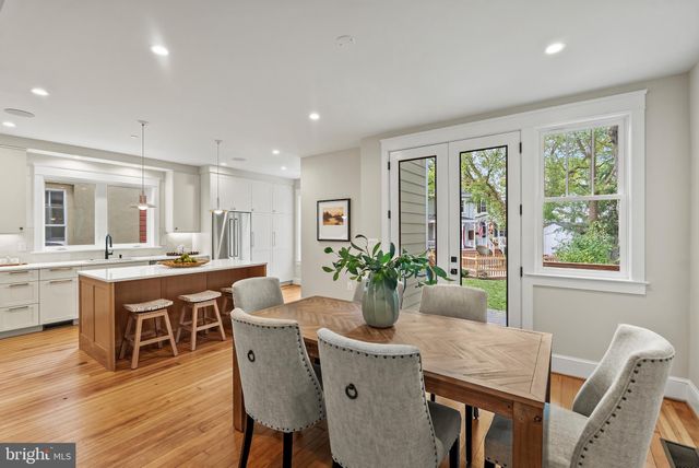 a dining room with furniture potted plants and wooden floor