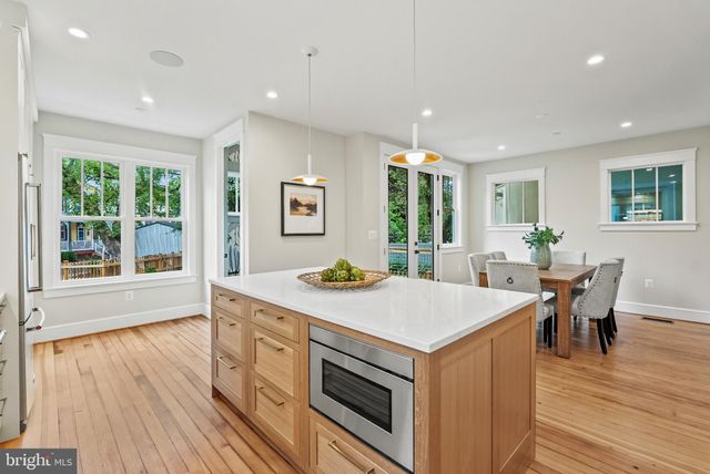 a kitchen that has a sink a table and chairs in it