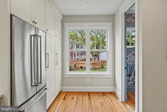 a view of hallway with a large window and wooden floor